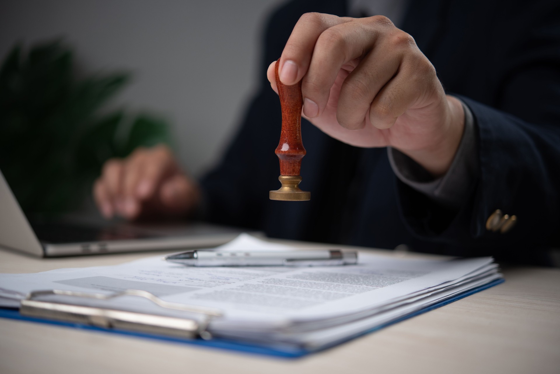 Confident Businessman Stamping Official Document in Modern Office Legal Approval Process Confident Businessman Stamping Official Document in Modern Office Legal Approval Process